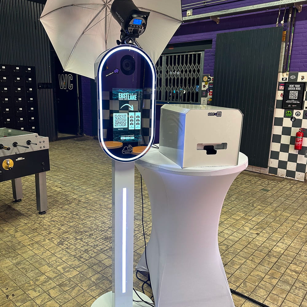 Luxe photobooth zuil met witte ringverlichting en printer op een statafel