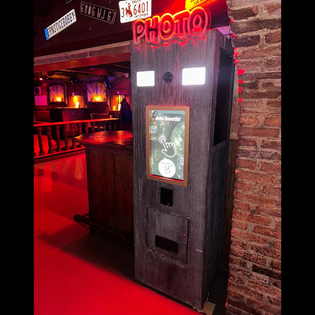 Custom photobooth in een horecazaak onder een neonbord
